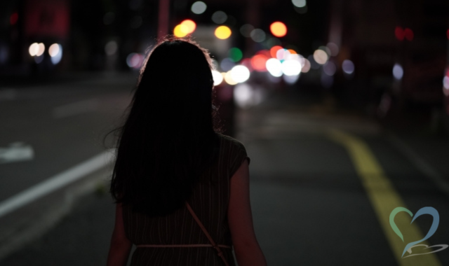 夜道を歩く女性の背中
