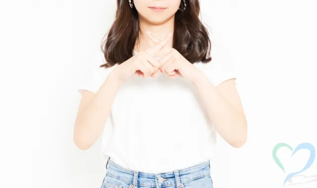 胸元でバツを作る人