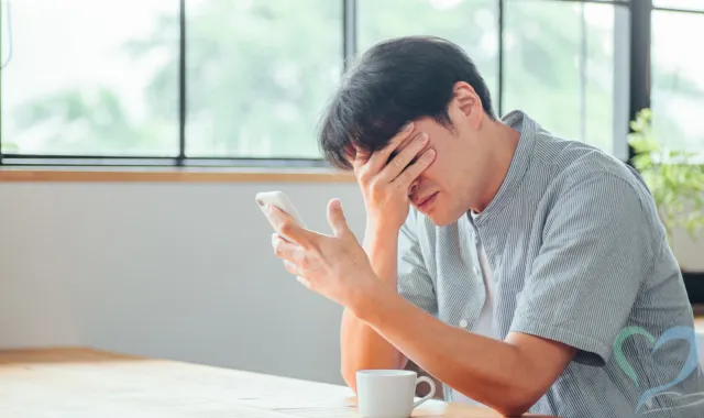 スマホを前にうなだれる人