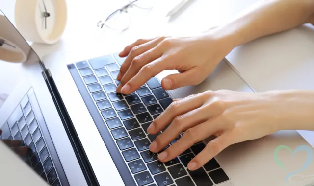 ノートPCのキーボードを打つ人