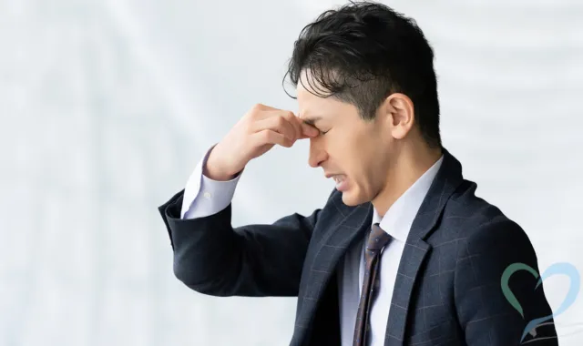 眉間を抑える人