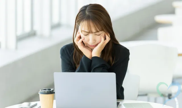 PCを前に悩む女性