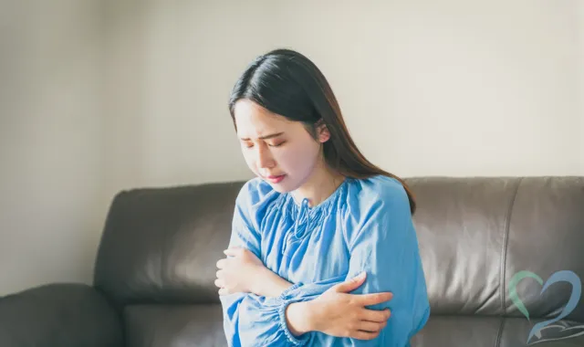 自らの体を抱く女性