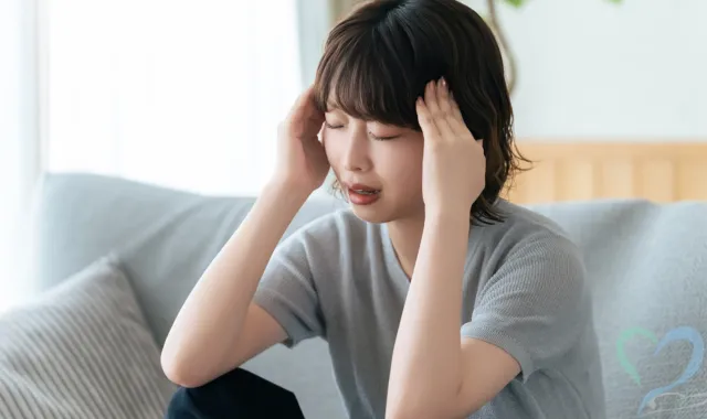 頭をおさえる女性