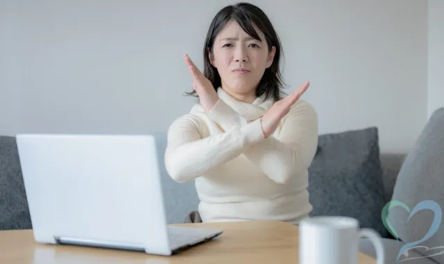 胸元でバッテンを作る女性