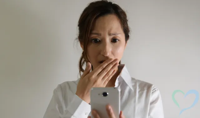 スマホを見て驚く女性