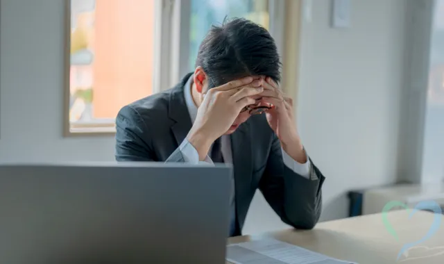 額を抑える男性