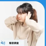 耳を抑える女性